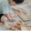 toddler using wooden alphabet tracing board
